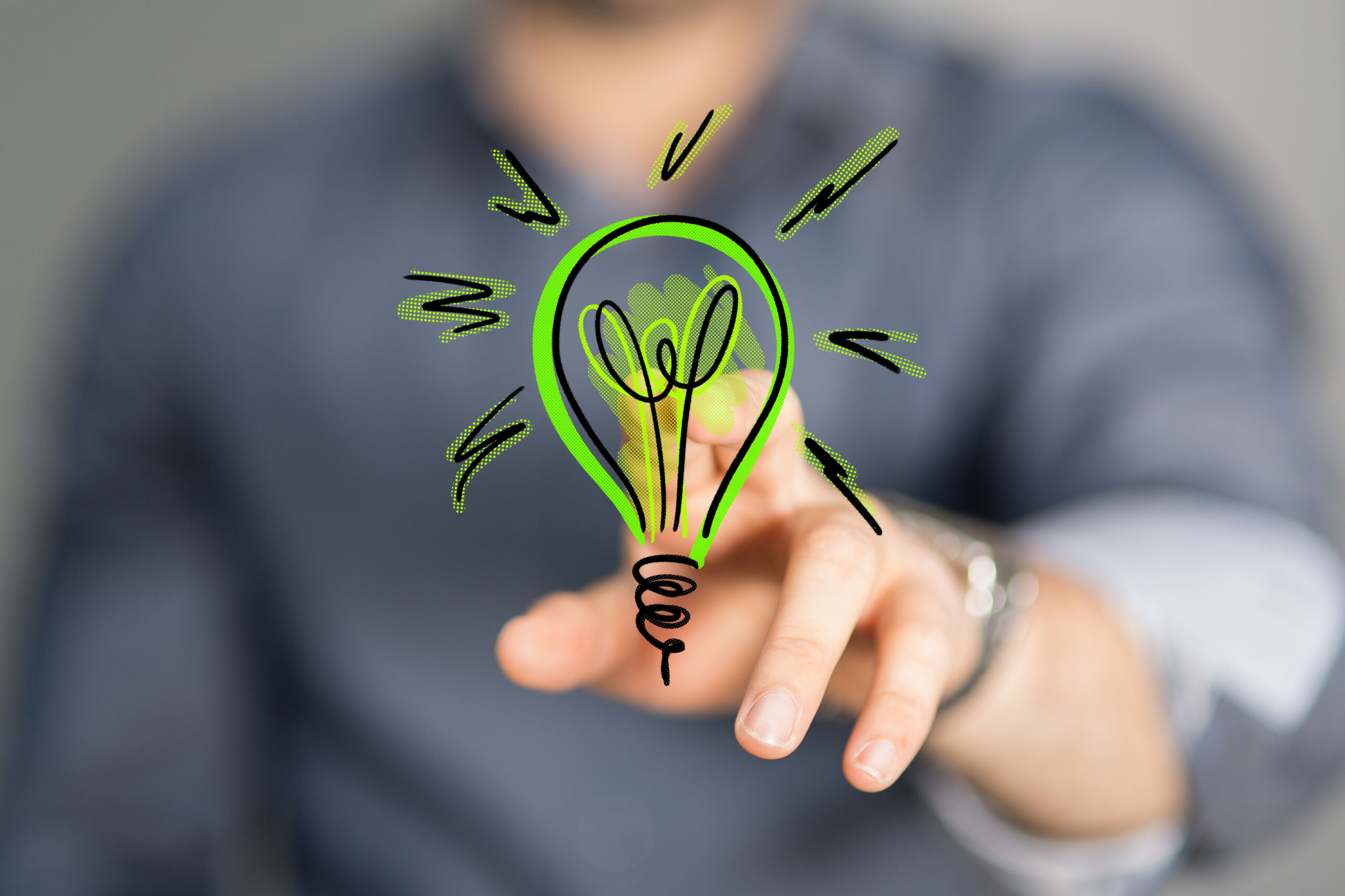 A man pointing at the screen at a green illustrated lightbulb.