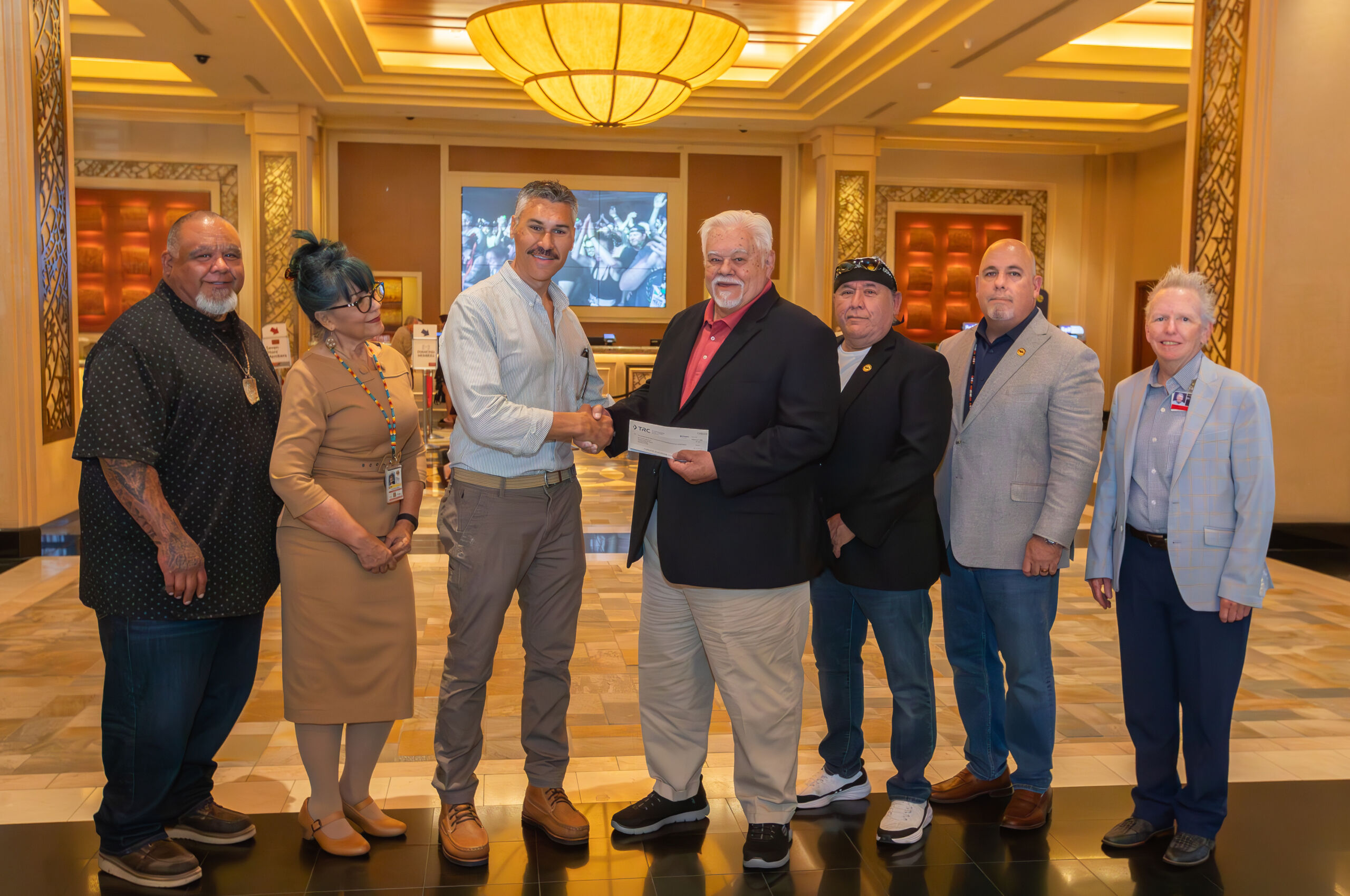 Group of people shaking hands accepting check